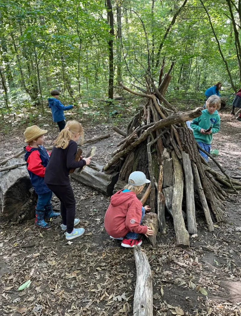 Kinder bauen ein Waldzelt im Wald